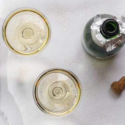 Directly Above Shot Of Champagne Flutes By Bottle On Table