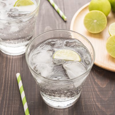 Fresh cocktail with soda, lime on a wooden background