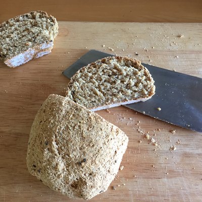 Sliced bread and knife on wooden table background.