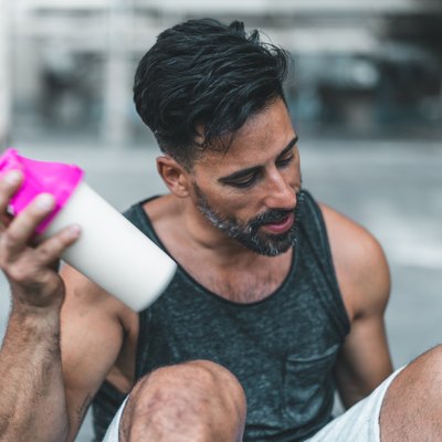 what to eat to gain muscle man mixing a Protein Shake after Exercising