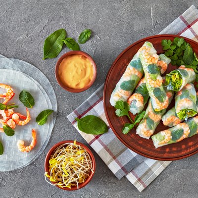 raw Asian spring rolls of rice paper with shrimps, rice noodle, lettuce and mint fillings