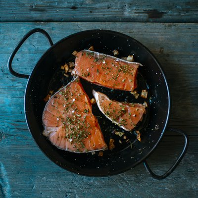 Salmon fillets in pan with parsley and garlic