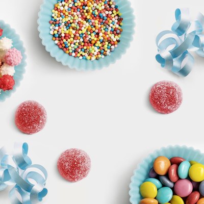 Blue paper cups full of sugar balls for decorating cakes