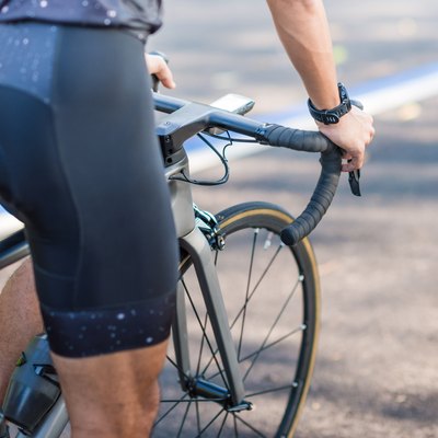 Young man cyclist riding mountain bike in public park at morning wearing cycling shorts