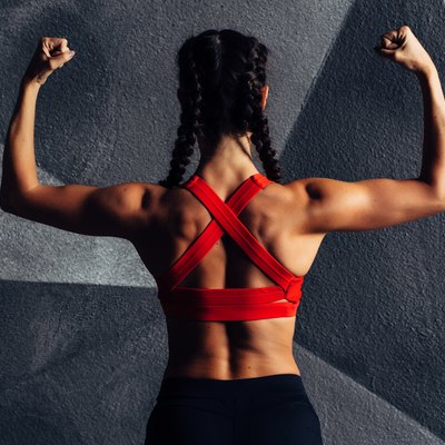 Back view portrait of a fitness woman showing biceps