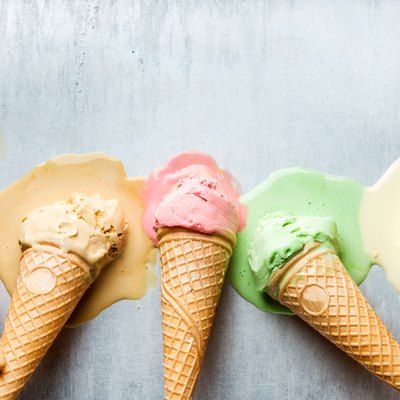 Colorful ice cream cones of different flavors. Melting scoops. Top view, steel metal backgroun