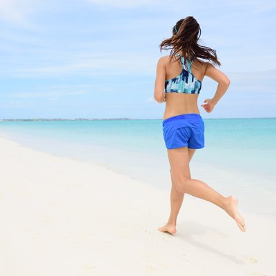 Runner training cardio running on beach