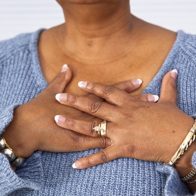 Senior African descent woman clutches chest in pain