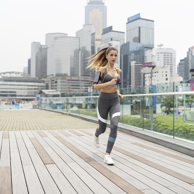 Blond sportswoman running on bridge