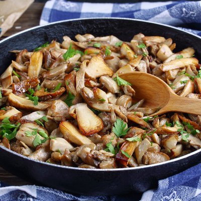 fried porcini mushrooms with parsley in skillet
