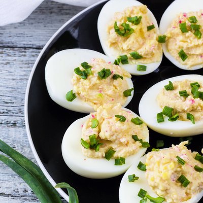 Home eggs stuffed with cheese and crab topped with green onions