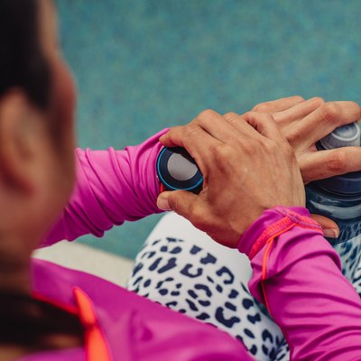 A woman dressed for exercise looking at her sports watch