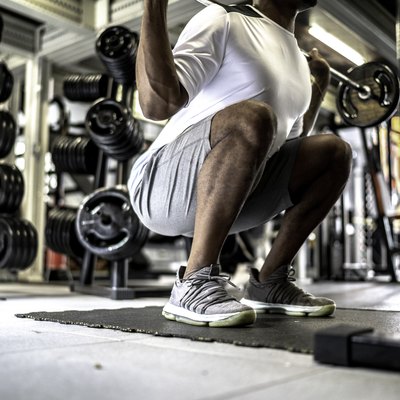 Man doing squat exercises in gym