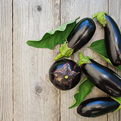 Ripe eggplants on a wooden background. Top view, flat lay.