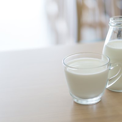 Close-Up Of Milk In Cup And Bottle On Table