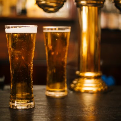 Glass of fresh and cold beer on wooden table