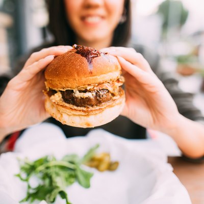 Woman eating impossible burger or beyond burger