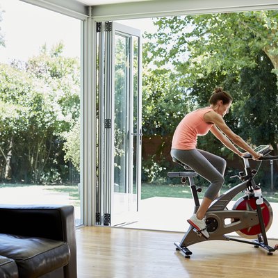 Woman working out on exercise bike at home