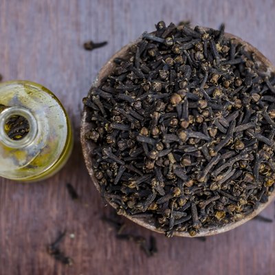 raw cloves,Syzygium aromaticum in a clay bowl with its oil beneficial for skin care and health care.