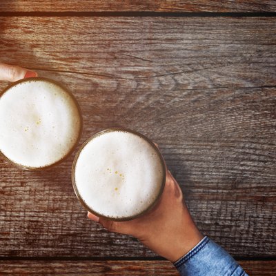 Cropped Hands With Beer On Table