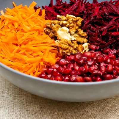 Salad of grated red beets carrots pomegranates and walnuts