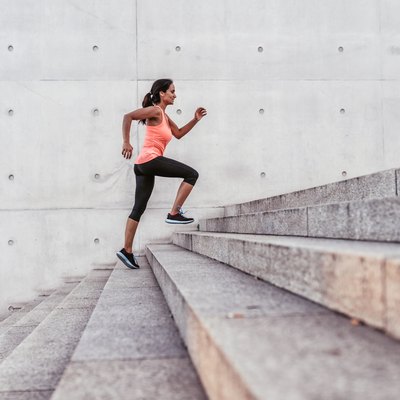 latina sports woman running up outdoor stairway in berlin