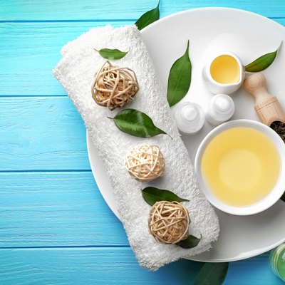 Spa composition with tea tree oil on blue wooden background