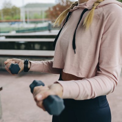 Girl training with dumbbells outdoors