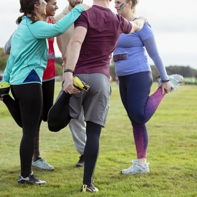 Competitors stretching legs together in park