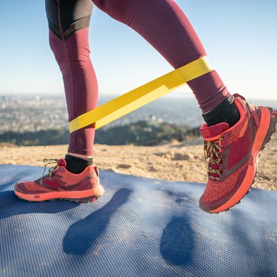 woman using mini resistance band for butt exercises outside