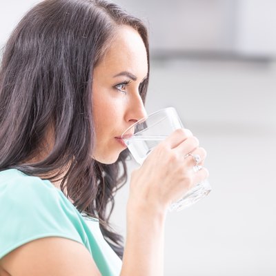 young woman drinks clean water adheres to drinking regimen