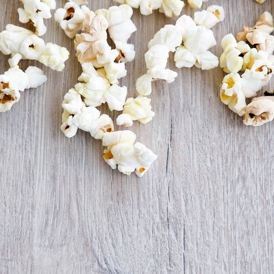 popcorn on wooden background, copy space, Scattered salted popcorn, texture background.