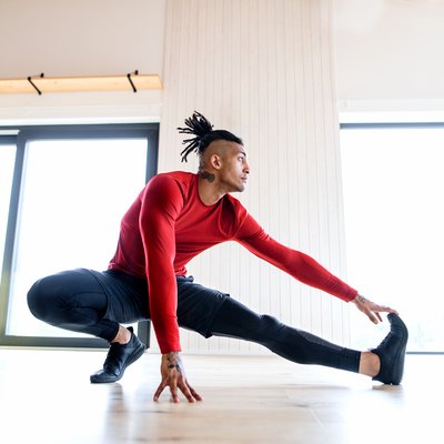 Man doing HIIT leg workout at home during halftime