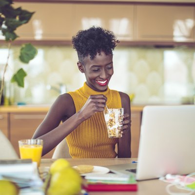Woman eating healthy breakfast in office