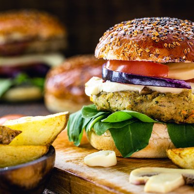 Prepared gluten-free veggie burgers with thick fries on platter.
