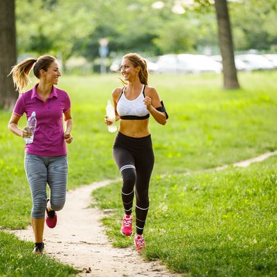 Young women running together in the park