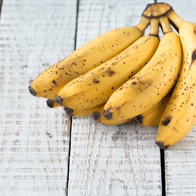 Raw Organic Bunch of Bananas Ready to Eat on wooden table
