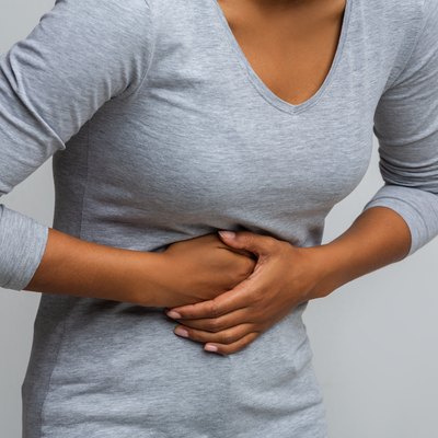 Woman suffering from gastritis, touching her tummy