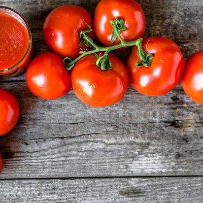 Glass of tomato juice on wooden table, flat lay from above