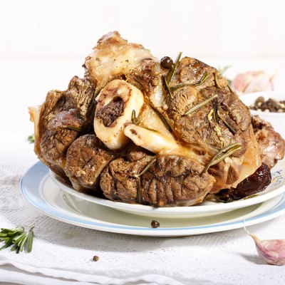 beef shanks with beef bone marrow braised with garlic rosemary and dried fruits. Rustic style.
