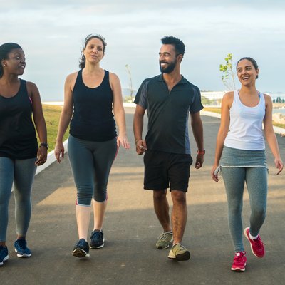 sporty friends walking on road against sky