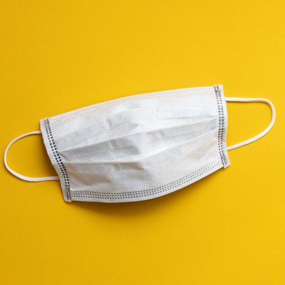disposable face mask on yellow background