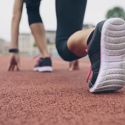 Woman on tartan track in starting position
