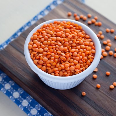 High Angle View Of Red Lentils In Container On Cutting Board