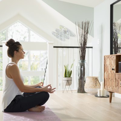 Serene woman meditating at home