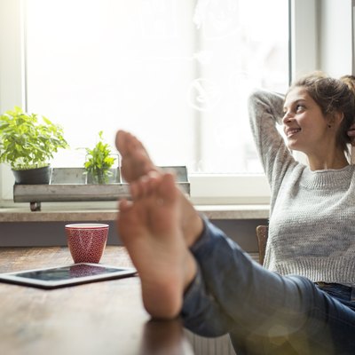 Woman sitting at table in kitchen relaxing