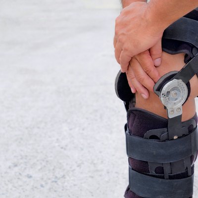 Cropped Image Of Man Wearing Knee Brace While Standing On Land