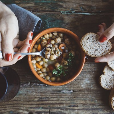 Woman eating foods high in sodium like soup and bread