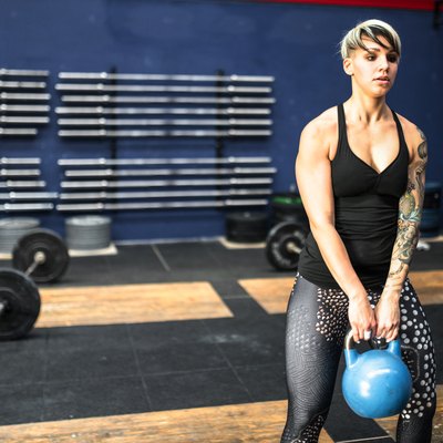 woman holding kettlebell in the gym to get lean