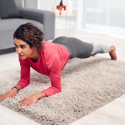 Woman doing a forearm plank exercise as part of a Pilates for beginners workout